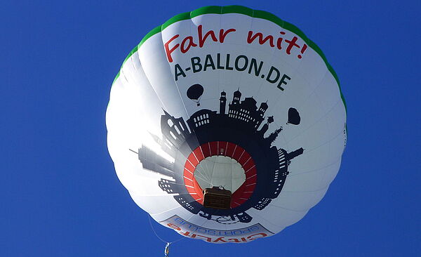 Fliegender Heißluftballon mit A-Ballon Werbung